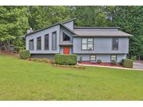 Charming home featuring a modern design, landscaped front yard, and a welcoming red front door at 3491 Birchwood Trl, Snellville, GA 30078