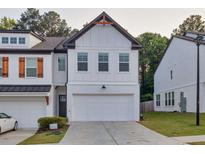 Charming two-story townhouse with white brick, a two-car garage, and contemporary design elements at 375 Auburn Valley Way, Auburn, GA 30011