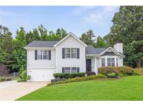 Charming two-story home with a well-maintained lawn, black door, and inviting curb appeal at 7108 Hummingbird Ln, Winston, GA 30187