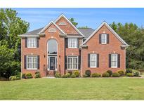 Charming two-story brick home with black shutters, a manicured lawn and mature landscaping at 1006 Kingsbridge Vw, Powder Springs, GA 30127
