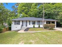 Charming ranch-style home featuring white brick, a cozy carport, and a lush front lawn at 2683 Rockcliff Se Rd, Atlanta, GA 30316