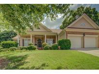 Charming home with a well-manicured lawn and a covered front porch with supporting columns, creating inviting curb appeal at 1065 Chippewa Oak Dr, Dacula, GA 30019