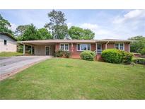 Charming single-story brick home with a covered carport and a well-maintained front yard with mature landscaping at 3332 Clay Rd, Austell, GA 30106