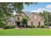 Charming brick home with manicured lawn, mature trees, and beautiful landscaping at 219 Deer Park Trl, Canton, GA 30114
