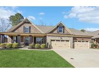 Charming home with a manicured lawn, inviting stone accents, and a spacious three-car garage at 266 Hanover Dr, Villa Rica, GA 30180