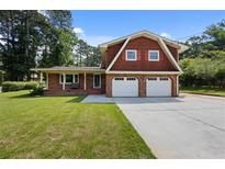 Charming home with a manicured lawn, attached two-car garage and brick accents at 3082 Briarleaf Dr, Decatur, GA 30034