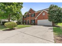 Charming two-story red brick home with a spacious driveway, attached garage, and well-manicured lawn at 750 Ambrose Ln, Atlanta, GA 30349