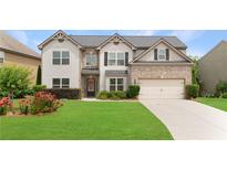 Beautiful two-story home boasts brick and siding exterior, well-manicured lawn, and attached two car garage at 4455 Orchard Lake Dr, Cumming, GA 30028