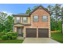 Charming two-story brick home with a two-car garage and well-manicured lawn at 364 Mossycup Dr, Fairburn, GA 30213