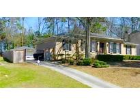 Charming brick home with well-manicured lawn, driveway, and lush landscaping at 3845 Pebble Beach Dr, Atlanta, GA 30349