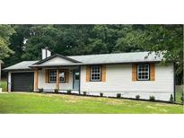 Charming single-story home featuring a garage, wooden shutters, and well-maintained landscaping at 2784 Oxford Dr, Decatur, GA 30034