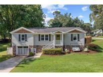 Charming home featuring a well-manicured lawn, inviting porch swing, and stylish architectural details at 984 Ridgecrest Se Dr, Smyrna, GA 30080