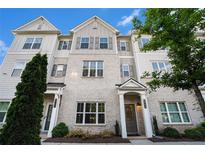 Beautiful townhome featuring a brick facade, gray shutters, and a well-maintained front yard at 1704 Evenstad Way, Smyrna, GA 30080