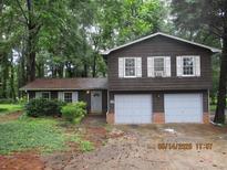 Charming split-level home featuring a two-car garage and mature landscaping at 5382 Rockbridge Rd, Stone Mountain, GA 30088