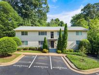 Inviting exterior of a light brick multi-Gathering home with well-maintained landscaping and reserved parking spaces at 449 Clairemont Ave # H3, Decatur, GA 30030