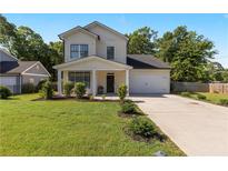 Charming two-story home featuring a well-manicured lawn and welcoming front porch at 1967 Cogar Dr, Decatur, GA 30032