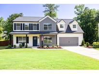 Charming two-story home featuring a well-manicured lawn, a two-car garage, and a welcoming front porch at 2720 Meridian Ct, Dacula, GA 30019