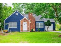 Charming blue home with a brick chimney and a well-manicured front yard at 6391 Katherine St, Douglasville, GA 30134