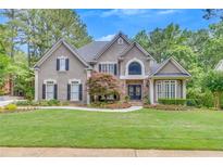 Charming two-story home with a manicured lawn and inviting stone accents at 407 Amber Ln, Woodstock, GA 30189