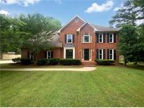 Charming two-story brick home with a well-manicured lawn and traditional architectural details at 110 Wyngate Way, Fayetteville, GA 30215