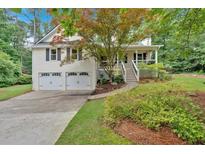 Charming home featuring a two-car garage, inviting front porch, and beautifully landscaped front yard at 328 West Ln, Woodstock, GA 30188