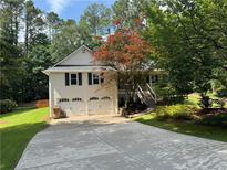 Charming two-story home with a well-manicured lawn and a two-car garage at 328 West Ln, Woodstock, GA 30188