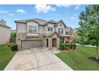 Charming two-story home featuring a stone facade, well-manicured lawn, and an attached two-car garage at 3291 Meadow Lily Ct, Buford, GA 30519