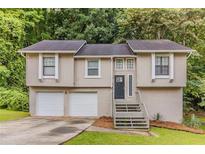 Charming two-story home featuring a two-car garage, neutral paint, and mature landscaping at 482 Tarragon Sw Way, Atlanta, GA 30331