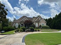 Stunning two-story home featuring a well-manicured lawn, circular driveway, and beautiful landscaping at 716 Bethpage Dr, Mcdonough, GA 30253