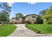 Charming two-story home featuring a stone facade, well-manicured lawn, and an inviting driveway at 3623 Doroco Dr, Atlanta, GA 30340