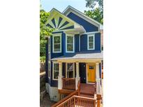 Charming two-story home featuring blue siding, white trim, and a welcoming yellow front door at 1454 Rome Nw Dr, Atlanta, GA 30314