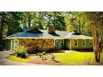 Charming single-story home with stone accents, mature trees, and a well-manicured lawn at 1516 Chase Ct, Riverdale, GA 30296