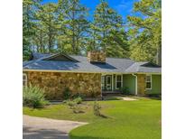 Charming, single story home with stone accents and a lush, green lawn at 1516 Chase Ct, Riverdale, GA 30296