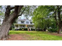 Charming two-story home with a large front porch and mature trees, situated on a well-manicured lawn at 4114 Falcon Shores Nw Ct, Acworth, GA 30101