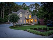 Charming home featuring a well-manicured lawn, inviting curb appeal, and mature trees at 1315 Woodland Trce, Cumming, GA 30041