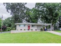 Charming one-story home featuring a red front door, brick accents, and a lush green lawn at 1982 Yucca Dr, Decatur, GA 30032