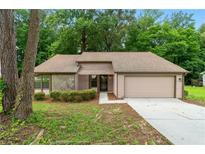 Charming single-Gathering home with a beige exterior and attached two-car garage, set amongst lush trees at 4818 Terrace Green Trce, Stone Mountain, GA 30088