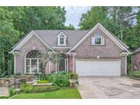 Charming brick home featuring an attached two-car garage and professionally landscaped front yard at 6520 Indian Acres Trl, Tucker, GA 30084
