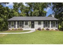 Charming, freshly painted single-story home with black shutters, landscaping, walkway, and inviting front entry at 2358 Armand Ne Rd, Atlanta, GA 30324