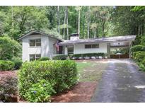 Charming single-story home with white painted brick, manicured landscaping, and covered parking at 2800 Mornington Nw Dr, Atlanta, GA 30327