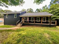 Charming home featuring a cozy front porch, black siding, and a well-maintained lawn at 124 Dockside Downs Dr, Woodstock, GA 30189