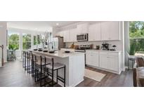 Modern kitchen featuring white cabinetry, stainless steel appliances, and a large center island with seating at 218 College Cir # 1012, Hapeville, GA 30354