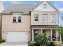 Charming two-story home featuring a brick facade, inviting porch, and a well-manicured front yard at 635 Opera Ln, Alpharetta, GA 30009