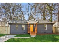 Charming home featuring a yellow front door, landscaped lawn and modern siding at 4179 Hanes Dr, Decatur, GA 30035