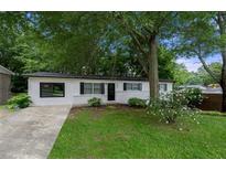 Charming single story home featuring a brick facade, well-maintained lawn and mature landscaping at 6402 Kensington Ct, Austell, GA 30106