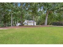 Charming single-story home with well-manicured lawn and mature trees at 408 Victoria Place Dr, Locust Grove, GA 30248