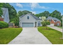 Beautiful traditional home with a well-manicured lawn and a long driveway leading to a two-car garage at 1950 Stethem Fry, Alpharetta, GA 30022
