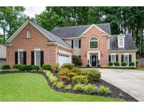 Charming brick home featuring manicured landscaping, black shutters, and a well-maintained lawn at 2192 Nine Oaks Nw Dr, Kennesaw, GA 30152
