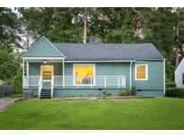 Charming bungalow-style home with covered porch, green lawn, and mature trees at 1170 Westmont Sw Rd, Atlanta, GA 30311