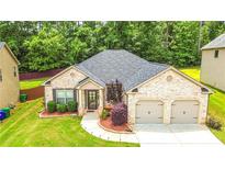 Charming brick home with a well-manicured lawn and a two-car garage at 4220 Sawgrass Dr, Lithonia, GA 30038